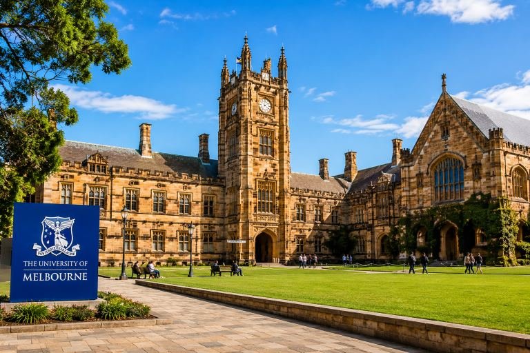 A university campus in Australia, a sandstone clock tower overlooking a green quadrangle.